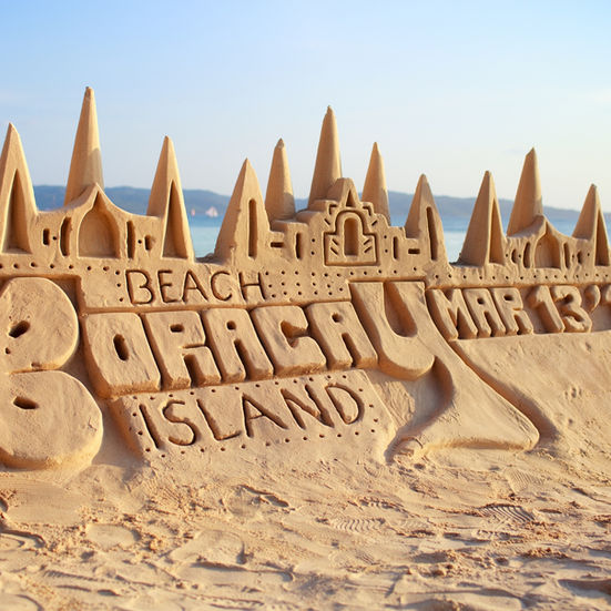 Boracay sand sculpture reading “Beach Boracay Island” with decorative towers on white sand