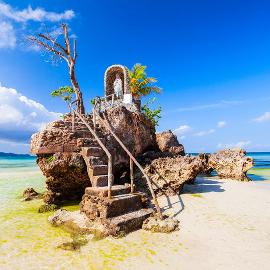 Rocky formation in Boracay with a staircase leading to a small seaside shrine