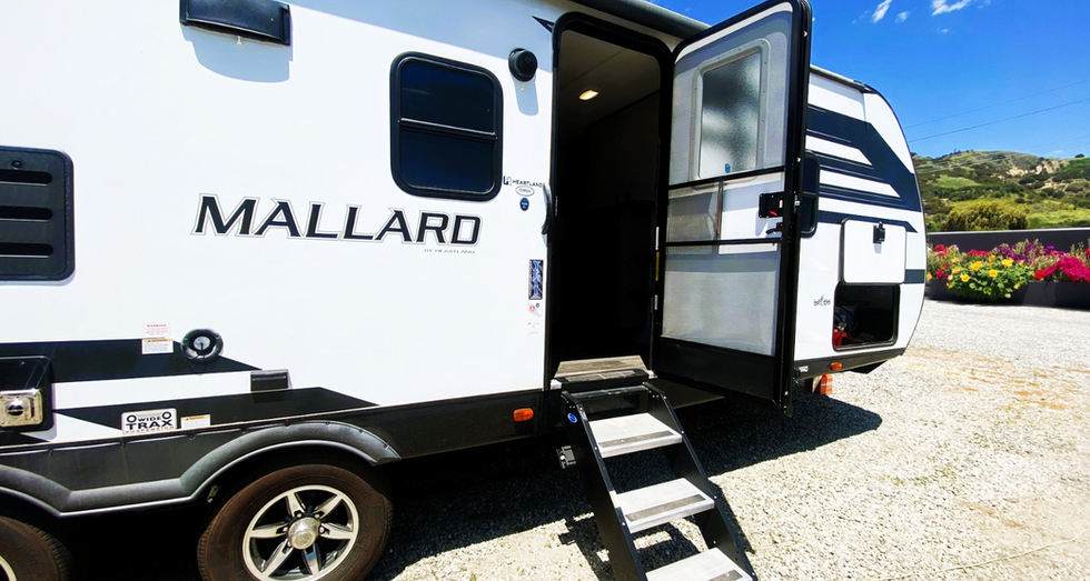 Entry door open on a travel trailer parked near Laguna Beach