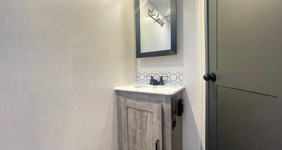 Private full bathroom inside the Legend Brownie travel trailer with shower, sink, and toilet for convenience