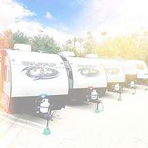 Row of travel trailers available for rent, parked under a blue sky. RV rentals in Southern California for camping, road trips, and temporary housing solutions.