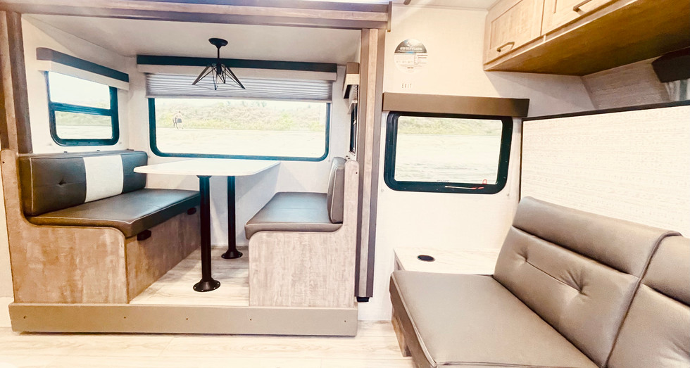 Comfortable dinette with seating in the Legend Brownie travel trailer, perfect for family meals and socializing