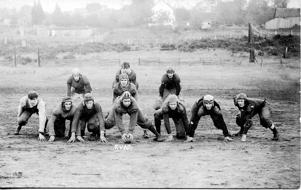 A group of football players forms a line of scrimmage in 1920.