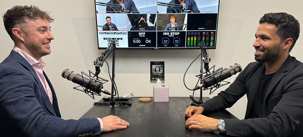 a photo of two young professionals sitting across from one another podcasting in a studio 