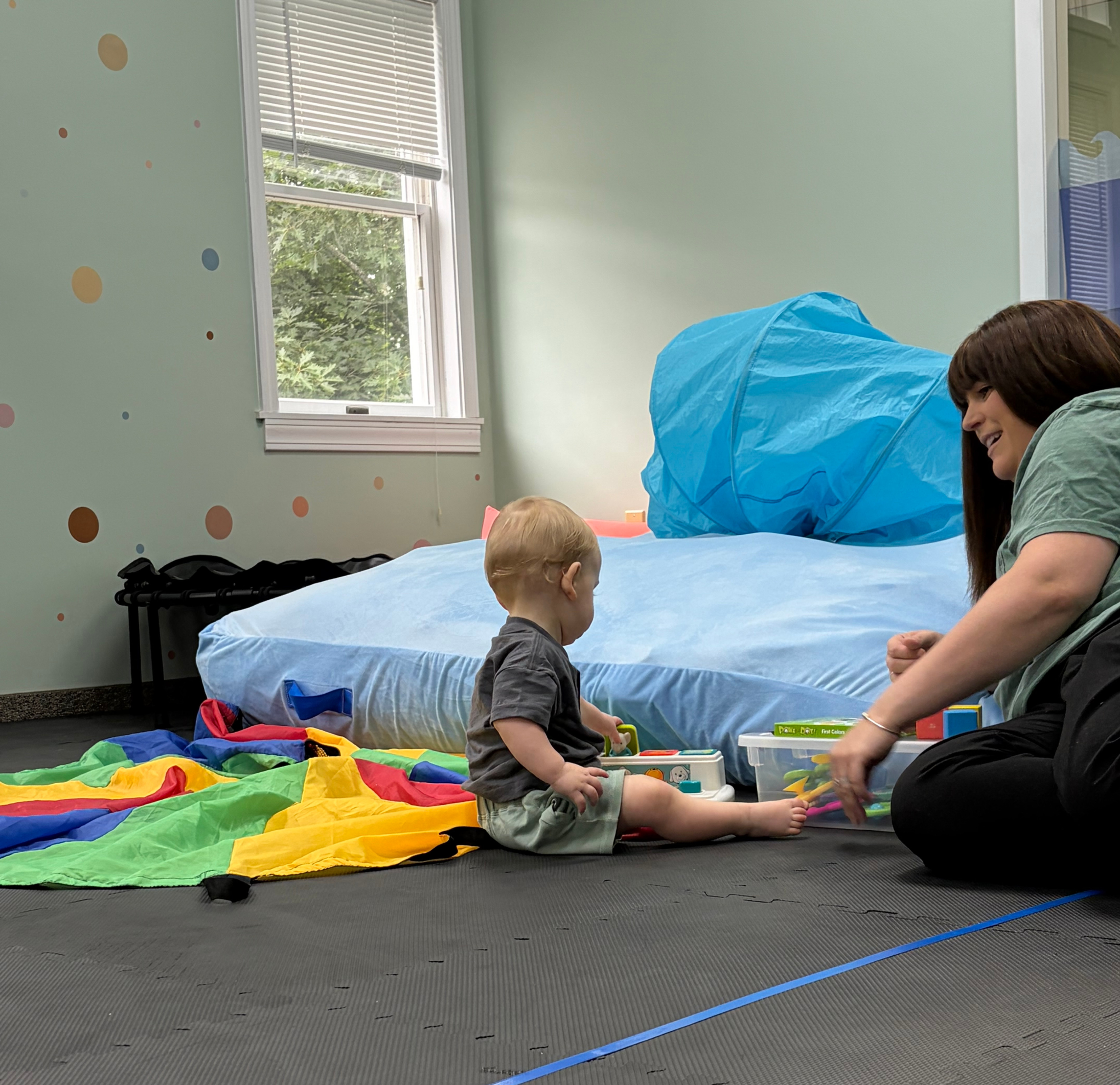 9-month old child working on bilateral coordination, postural control, and early cognitive development