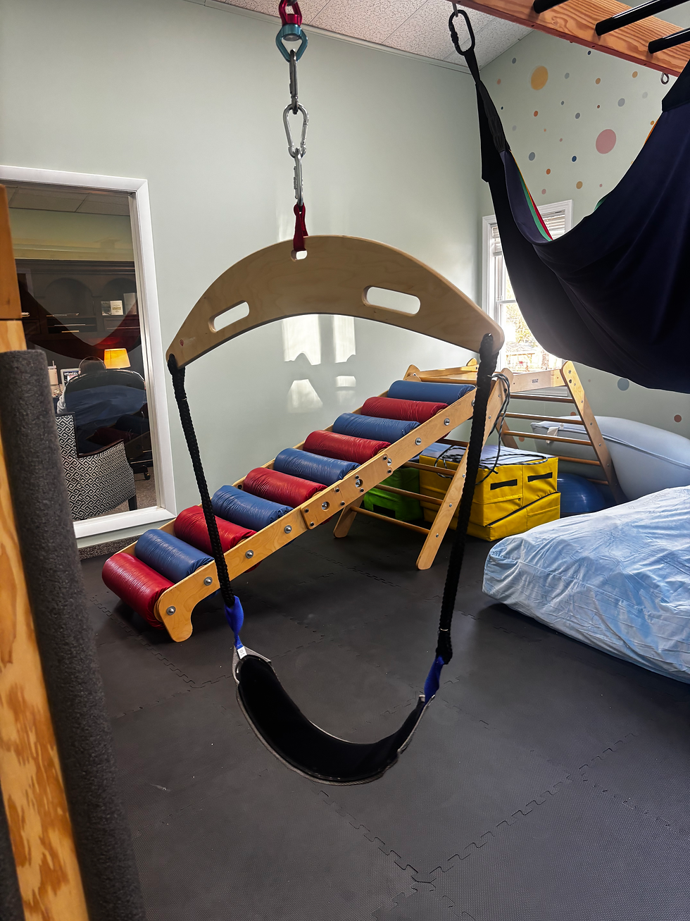 Close-up view of a child using a frog swing in a sensory gym