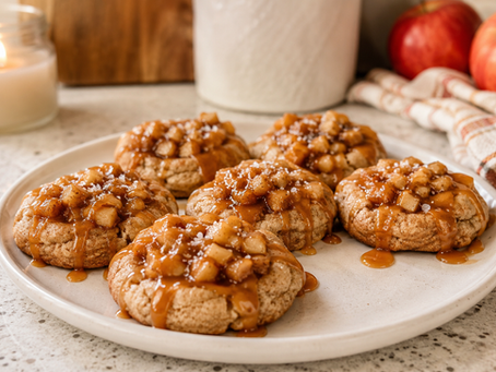Bakery-style salted caramel apple pie cookies topped with warm apple pie filling and caramel drizzle on a white serving platter.