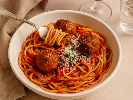 Spaghetti and meatballs in a white bowl with red sauce