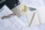 A Notebook and Pen Near the Laptop and Documents on the Table