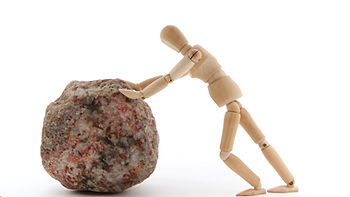 Man pushing rock obstacle