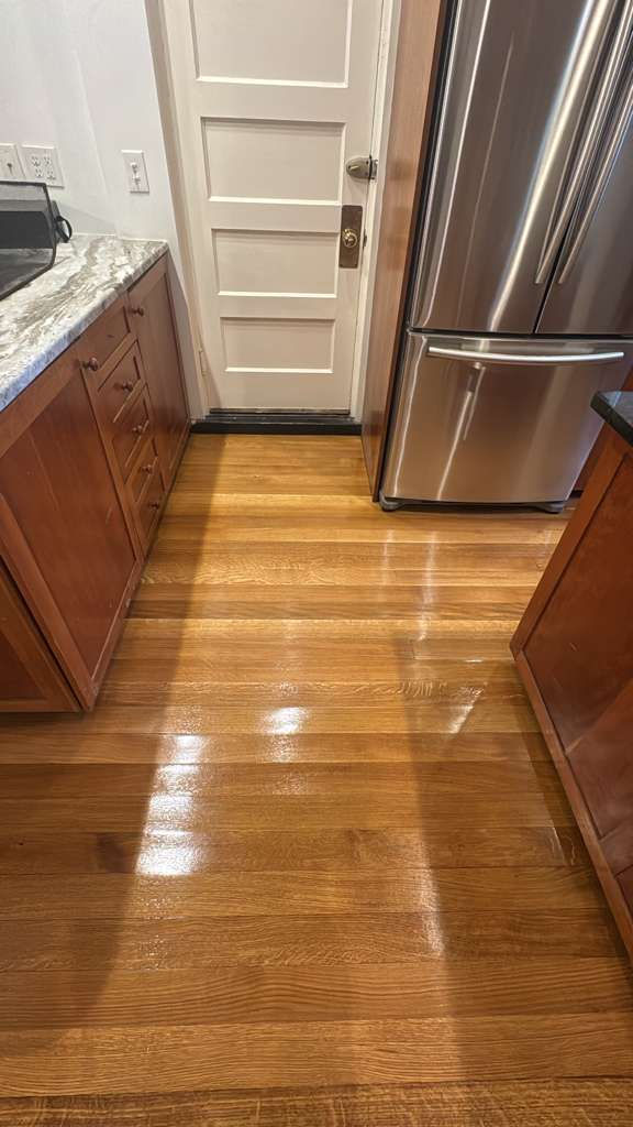 Kitchen with wooden floor and stainless steel appliances.