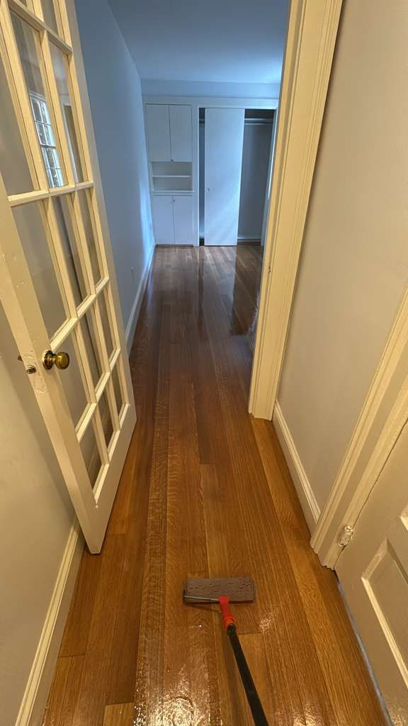 Hallway with wooden floor and glass-paneled door.