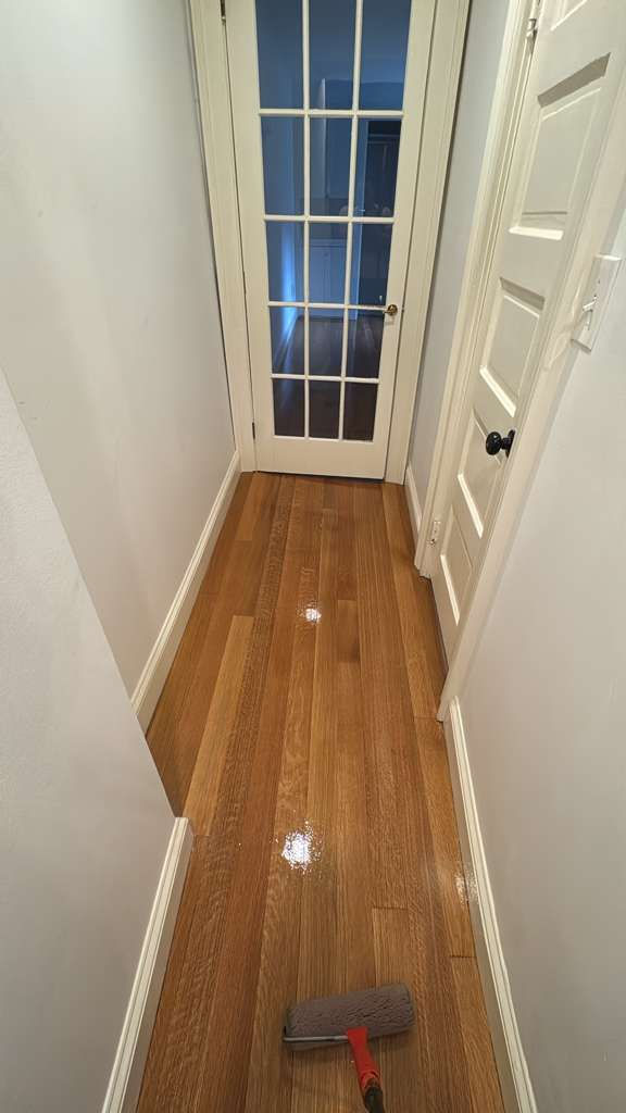 Shiny wooden floor in a narrow hallway.