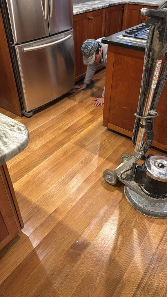 Wooden floor being polished with a cleaning machine.