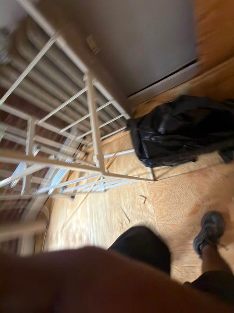 Room corner with a metal bed frame.