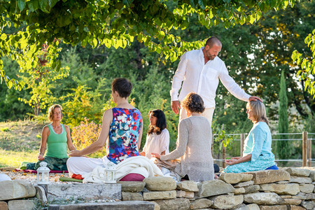 Spiritual teacher Daniel Hertlein places his hand on the head of a participant at a retreat in Italy and gives her Shaktipat.