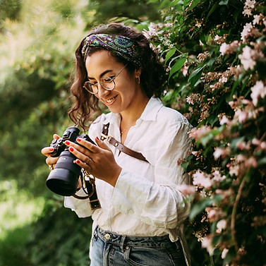 Portrait einer lachenden Frau mit Kamera in der Hand