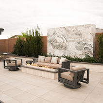 Outdoor patio seating with a fire pit and marble wall. Outdoor fire pits Las Vegas.