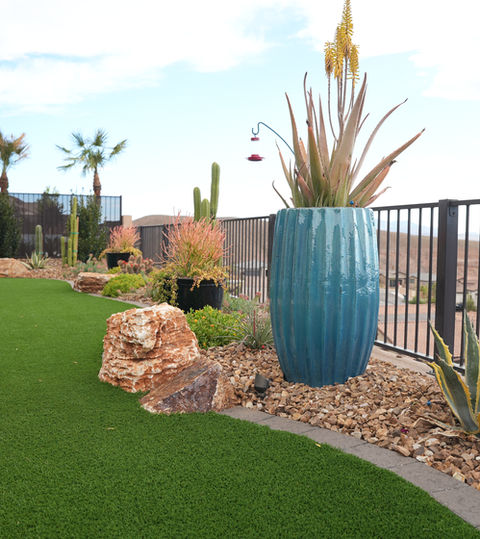 Desert backyard landscaping with artificial turf and drought-tolerant plants