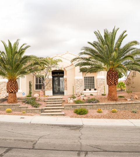Residential home with palm trees, front entry and courtyard in Las Vegas. LivingWaterLV