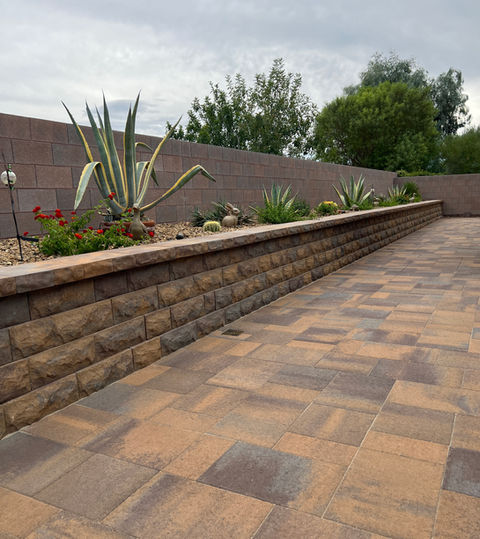 Landscaped retaining wall with stone pavers