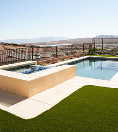 Residential pool with spa, green grass, and scenic background view Pools & Landscapes LivingWaterLV