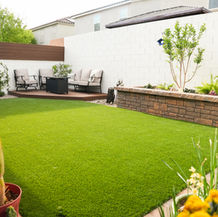Artificial turf lawn with patio furniture and desert plants