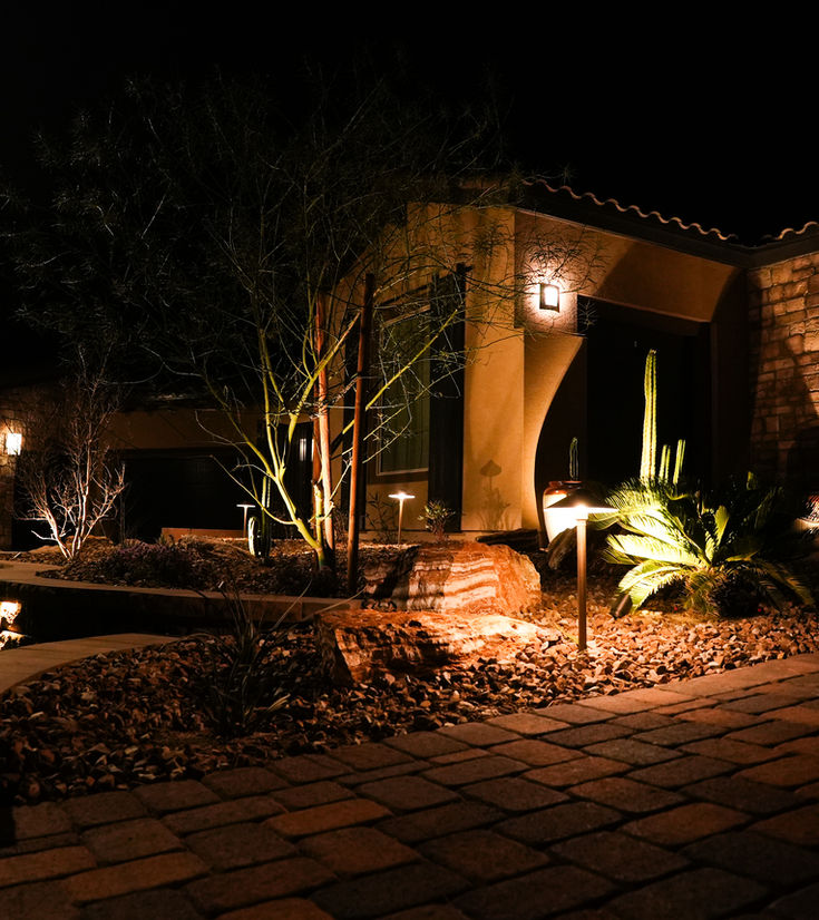 Night view of house illuminated by warm landscape lighting