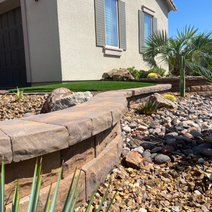 Landscaped yard featuring a curved retaining wall.