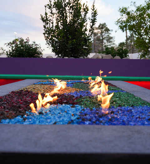 Modern fire pit with colorful glass accents in a Las Vegas backyard.