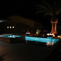 Night view of modern pool and spa with dramatic lighting