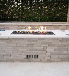Modern gas fire pit with a stone design and clean, contemporary lines.