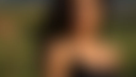 A woman outdoors, reflecting, and taking a deep breath.