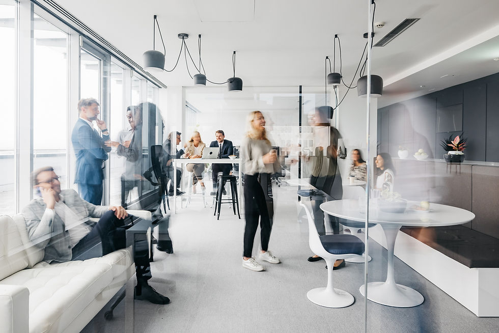 Blurred motion of people networking and working in a modern office lounge.