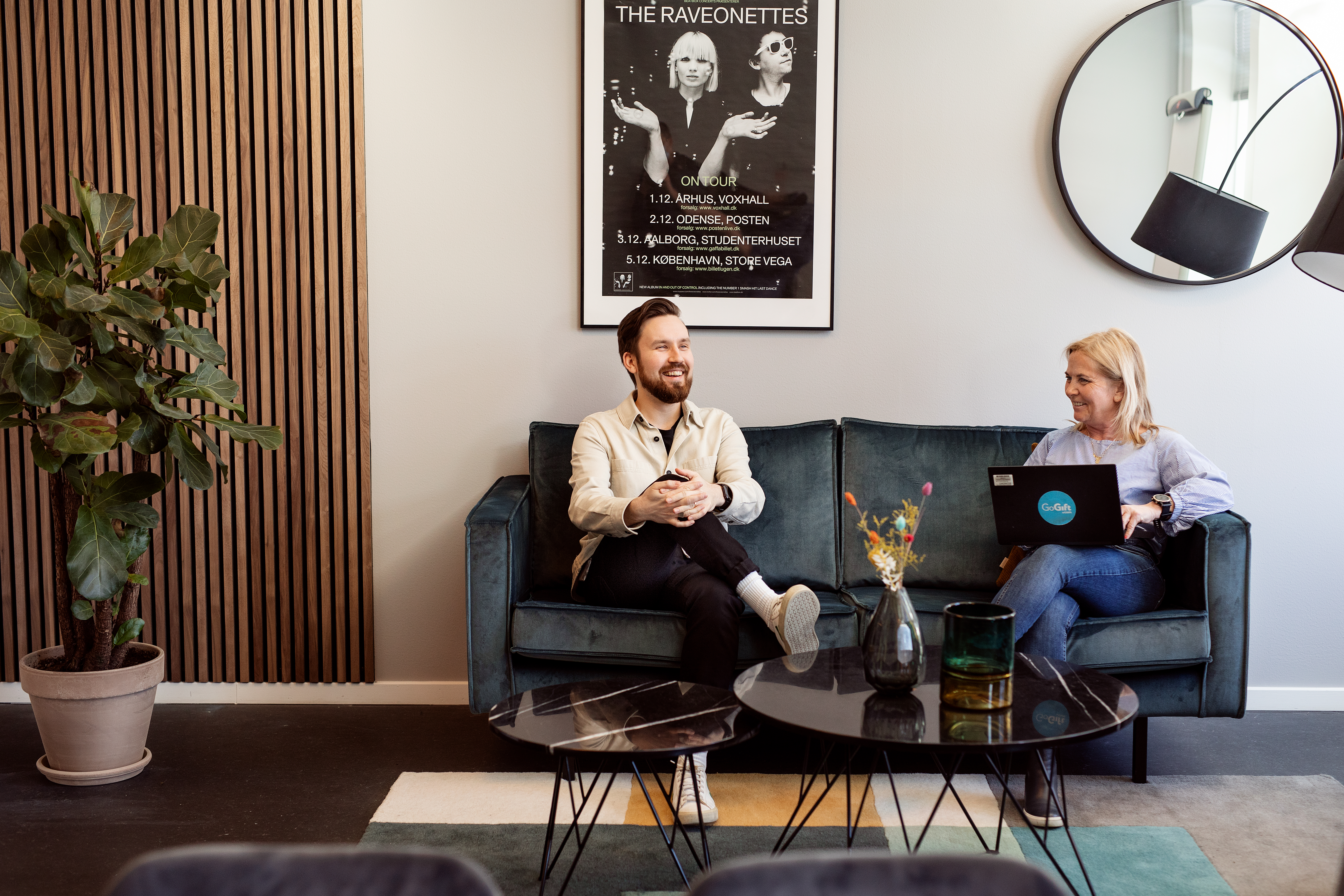 Two people having a meeting in an office lounge area and smiling