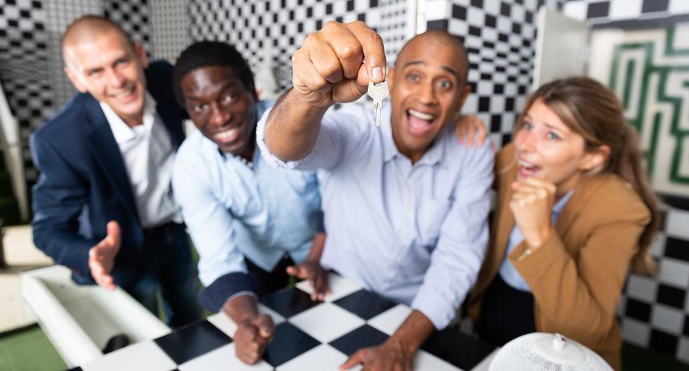 Excited group celebrating after solving an escape room, one person proudly holding a key.