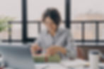 A woman opening a gift in her work desk while smiling