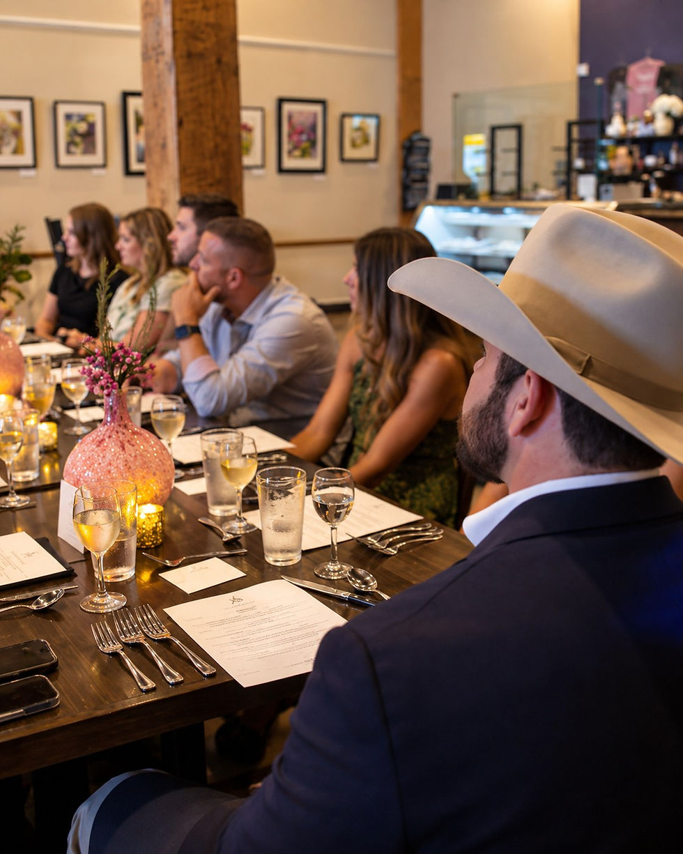 Guests at a long candlelit table during a wine dinner