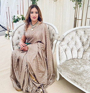 Woman in beige saree sitting