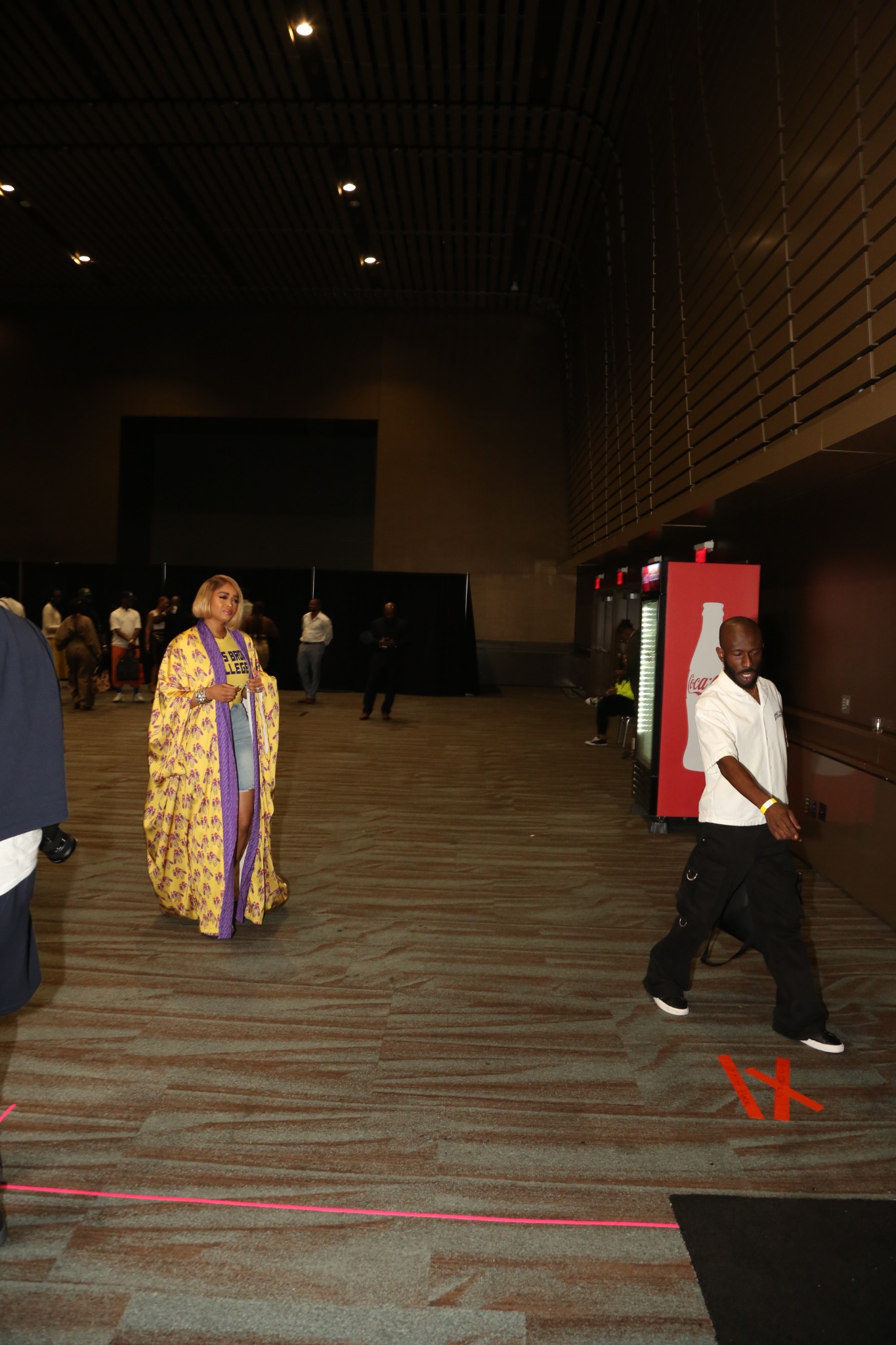 Timothy Jenkins pointing toward a floor position while talent walks behind him at an event