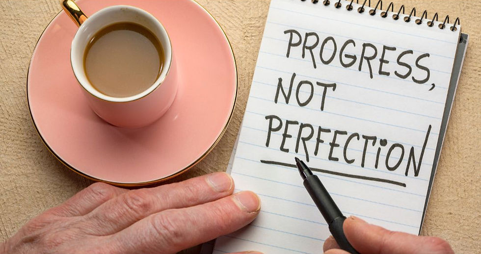 Handwritten note with the phrase progress over perfection on a journal page.