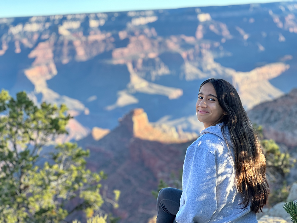 Teen sitting at a scenic overlook, reflecting while taking in a wide view