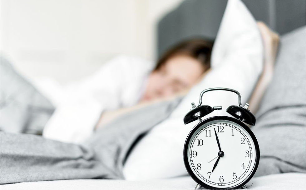 Alarm clock beside sleeping teen practicing a summer wake-up routine