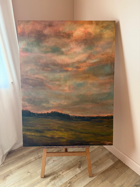 a large painting of a field is on an easel