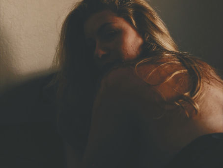 Woman sitting by a window holding coffee during a quiet morning moment