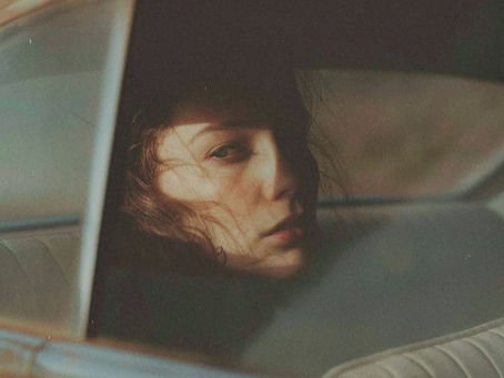 Woman looking thoughtfully through a car window, reflecting on how life can take an unexpected path.