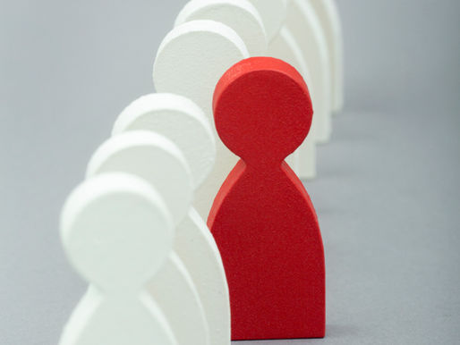 Une silhouette rouge sort du rang de silhouettes blanches
