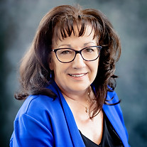Smiling woman with glasses in a blue blazer
