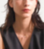 Woman wearing a necklace with a small pendant, simple and elegant.
