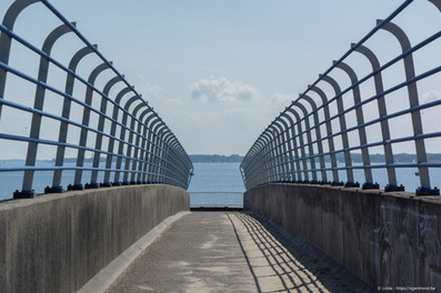 Een voetgangersbrug over de drukke N57, van de parking naar het strand.